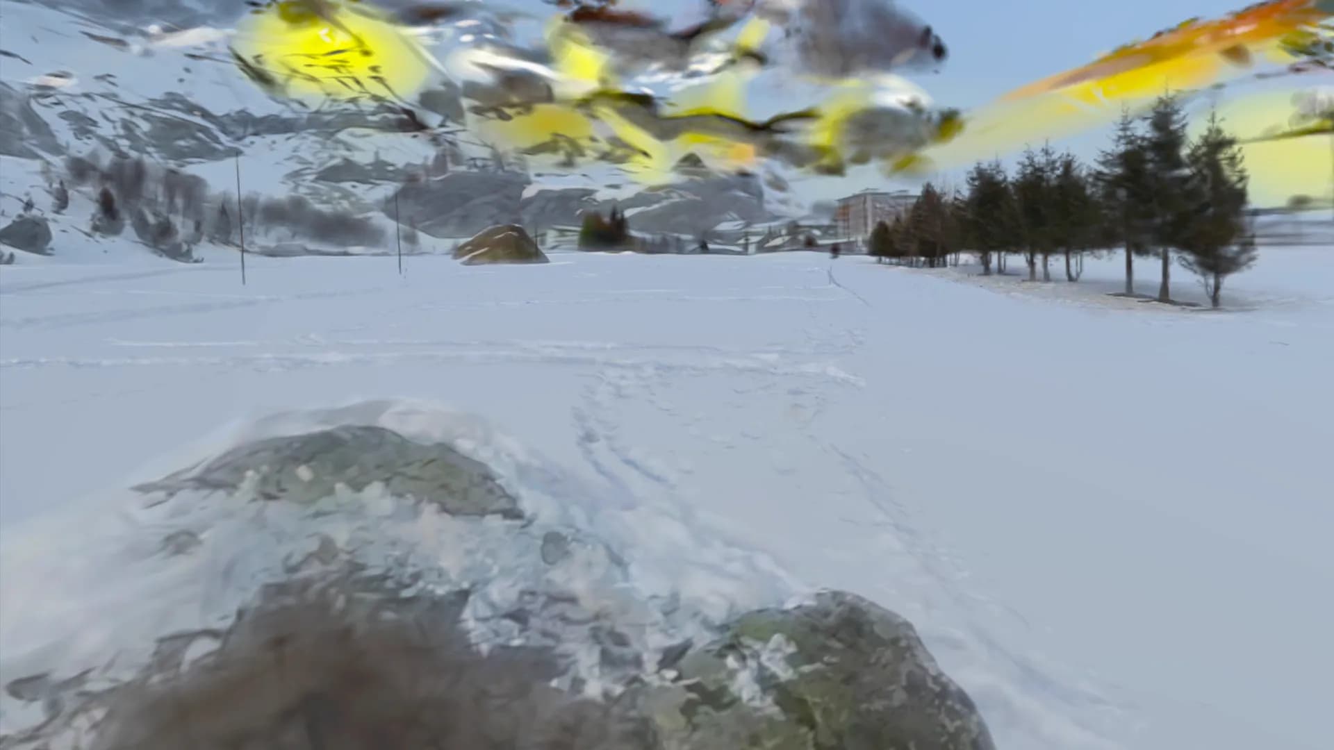 A snow-dusted boulder in an open field
